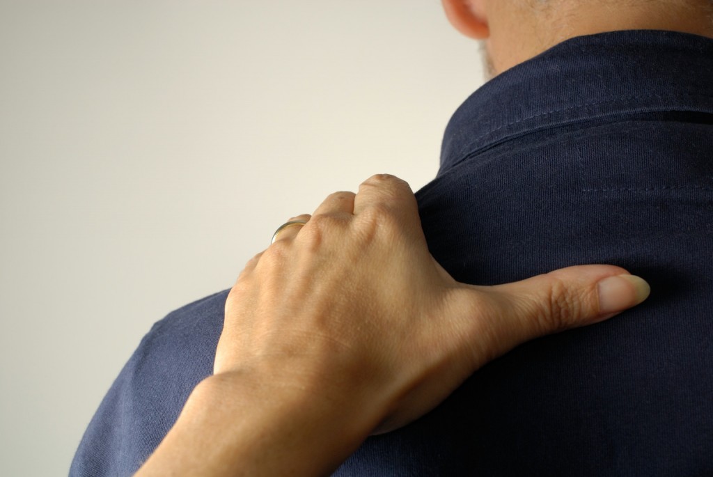 Woman resting hand on man's shoulder, close-up, rear view